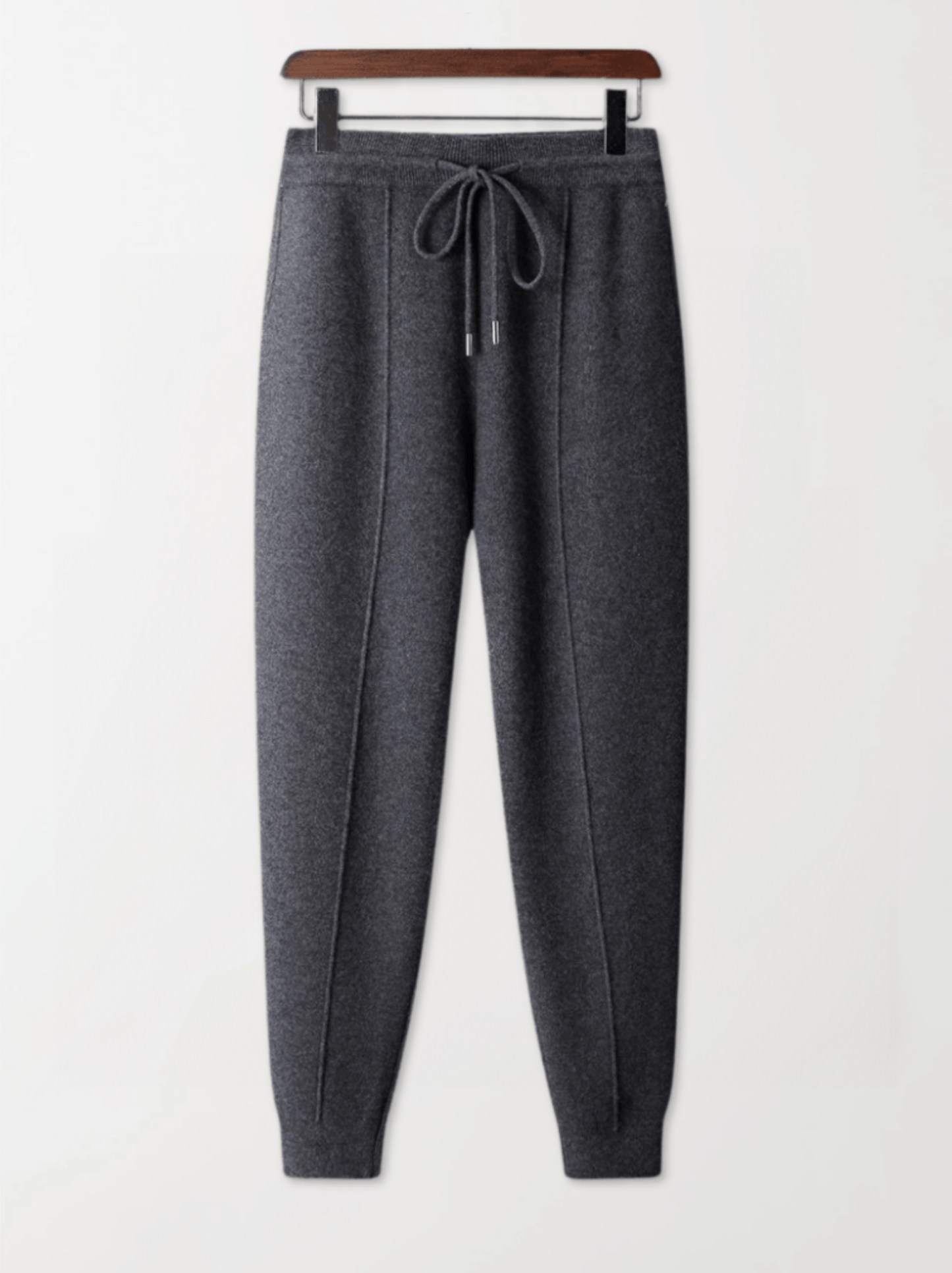 Gray sweatpants on a hanger against a white background