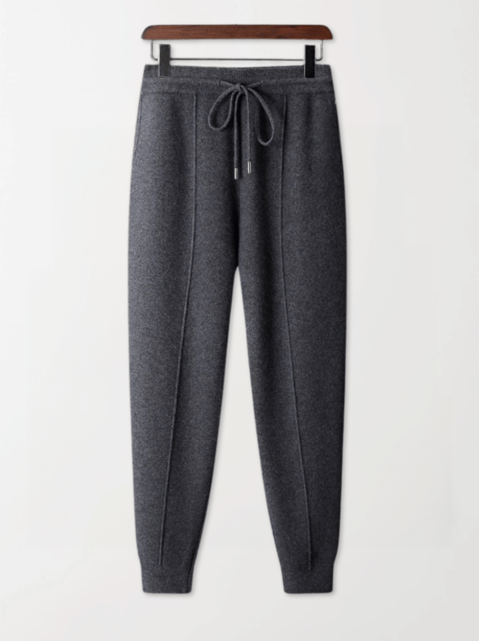 Gray sweatpants on a hanger against a white background