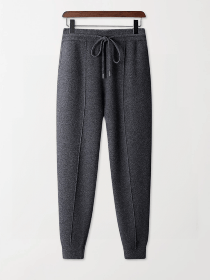 Gray sweatpants on a hanger against a white background