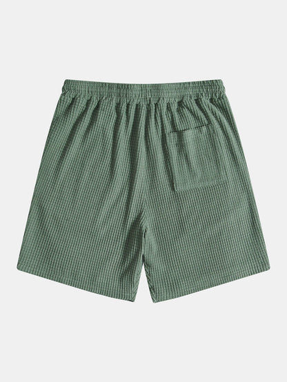 Green checkered shorts on a light gray background