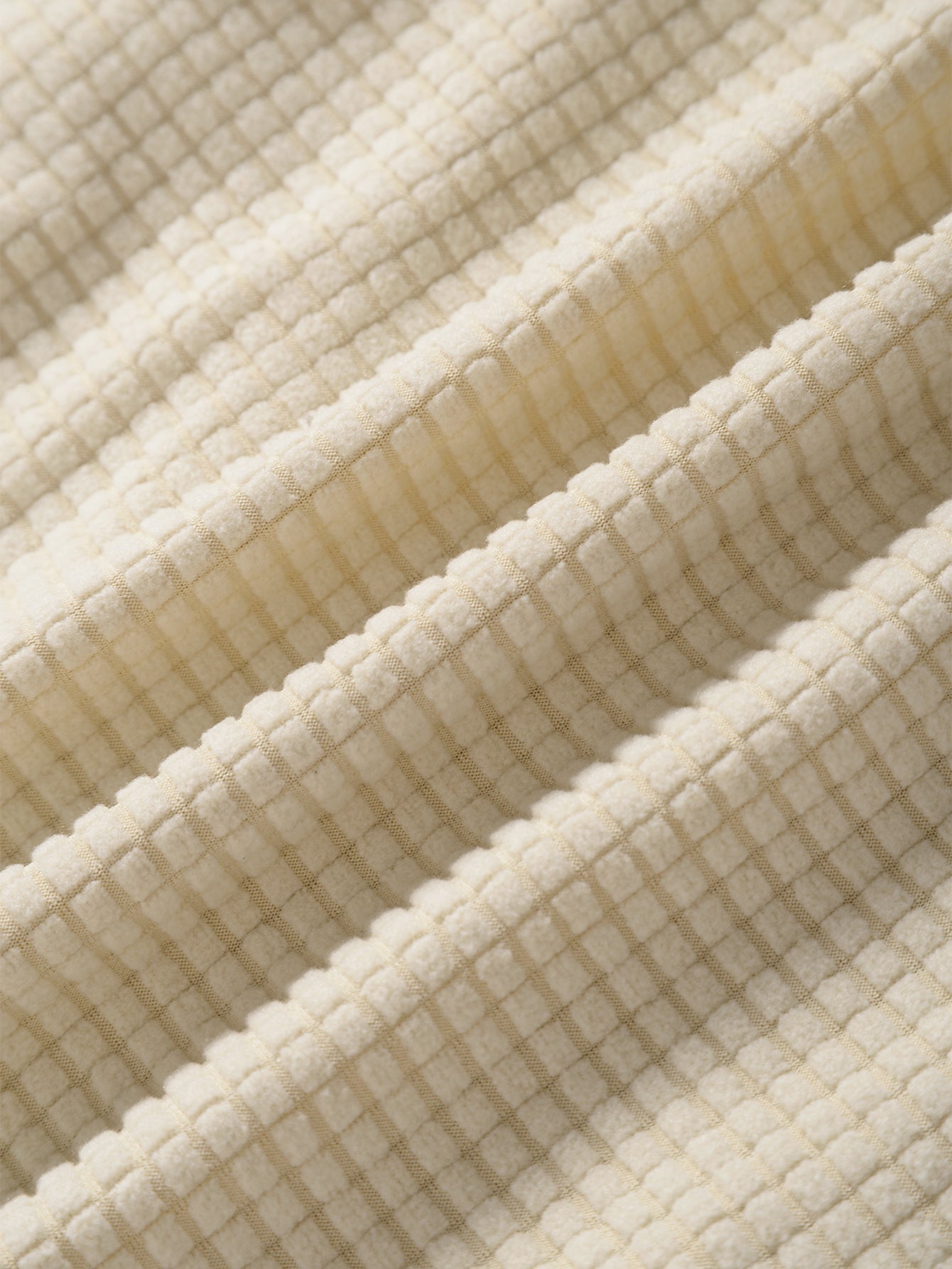 Close-up of textured beige fabric with a grid pattern