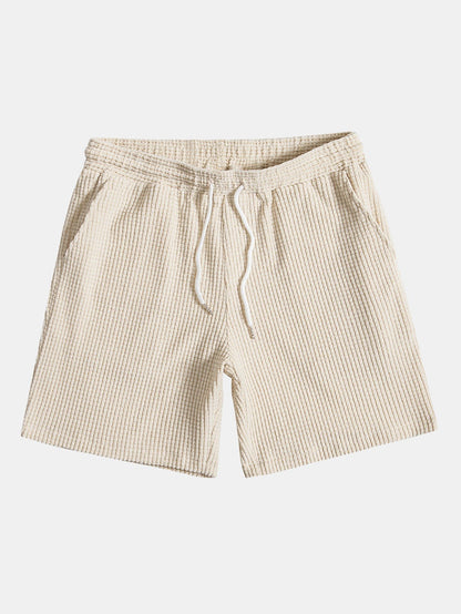 Beige shorts with a drawstring on a white background