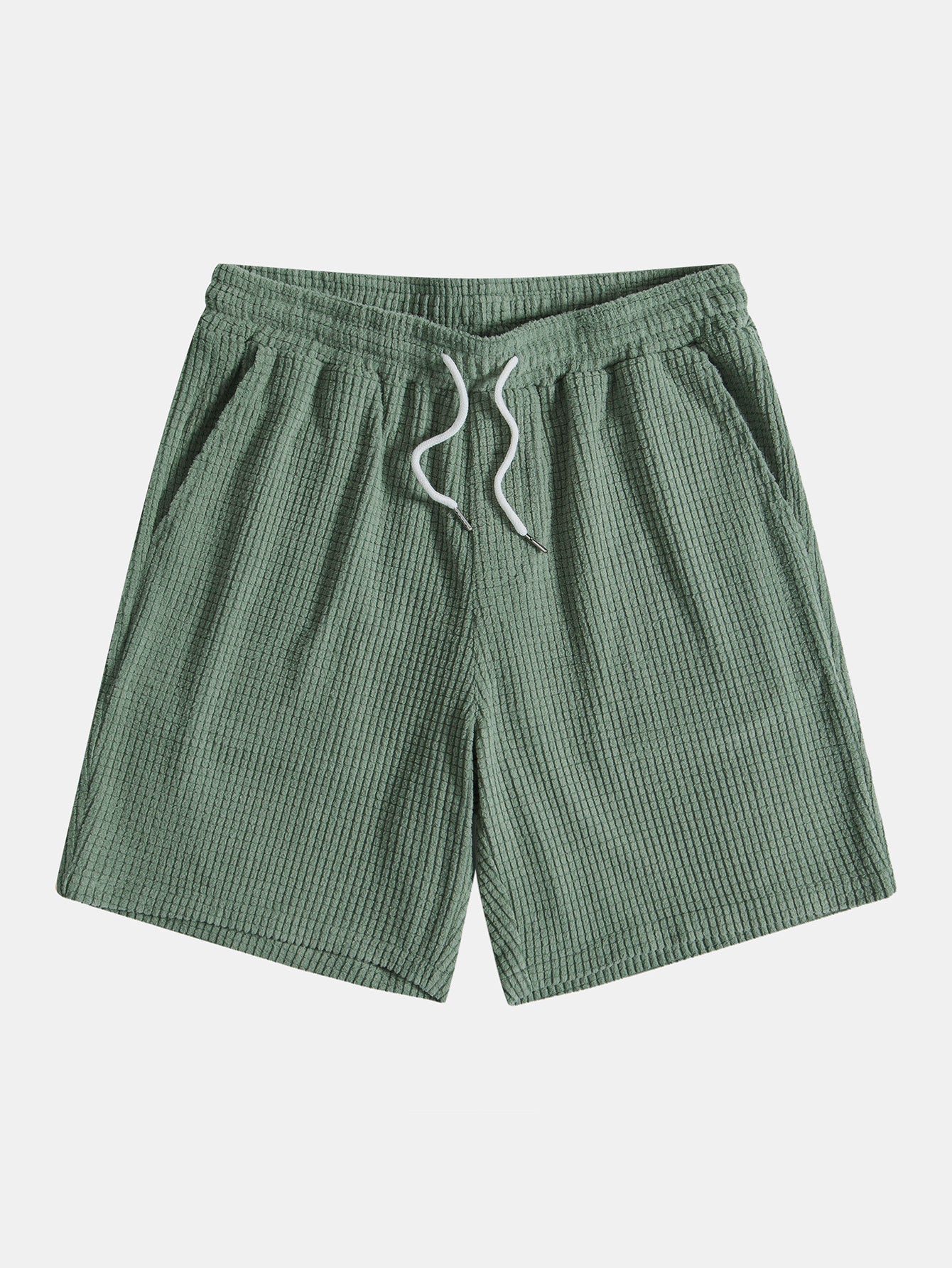 Green shorts with a drawstring on a light gray background