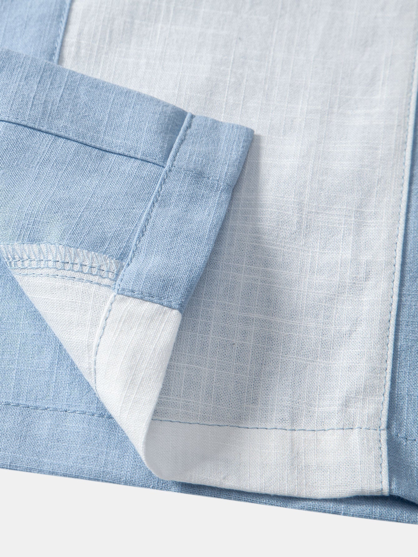 Close-up of a blue and white checkered fabric with a pocket detail.