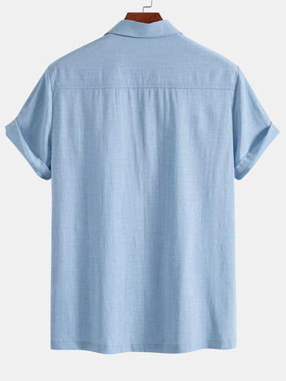 Light blue short-sleeve shirt on a hanger against a white background