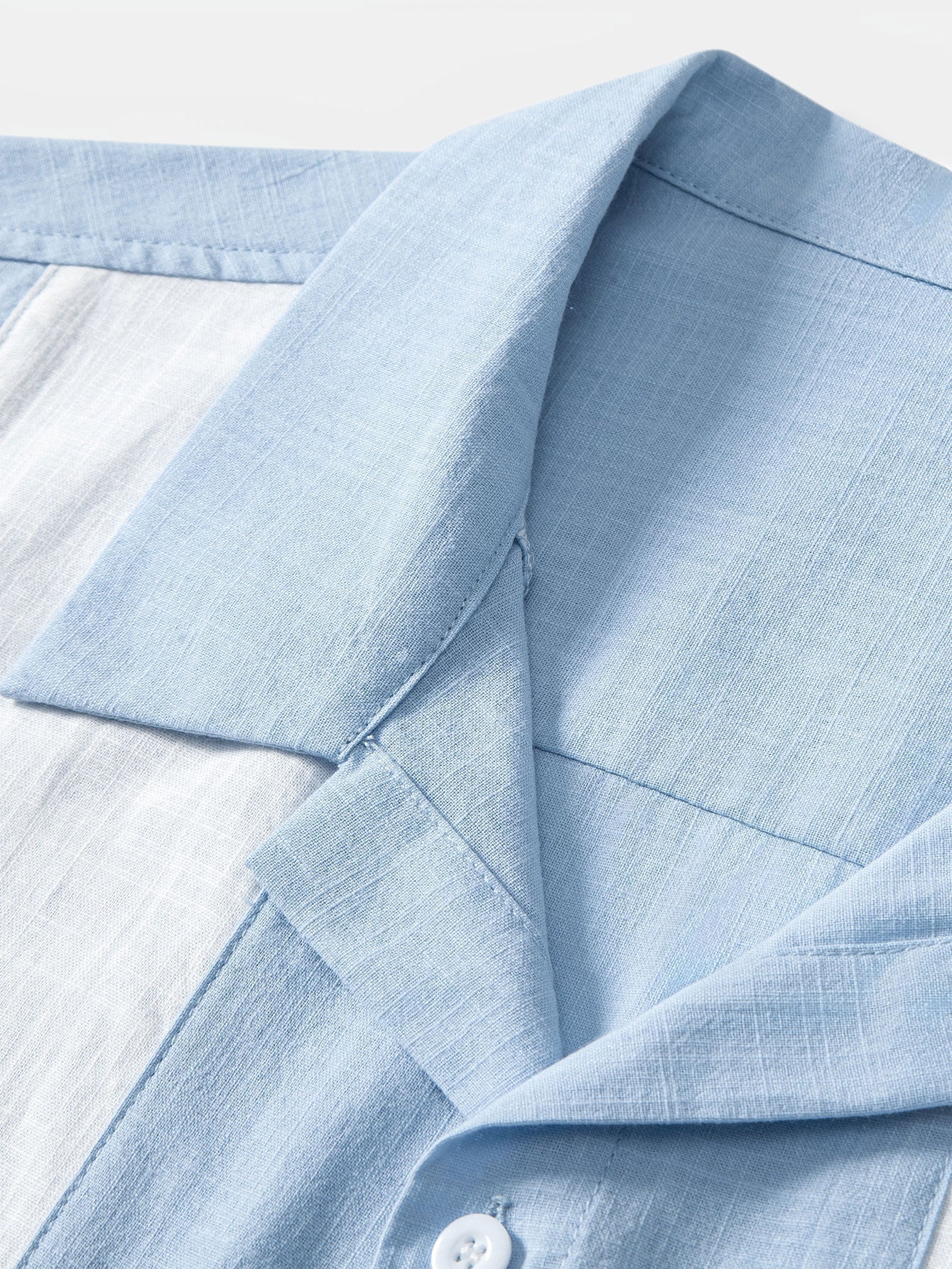 Close-up of a light blue shirt collar on a white background