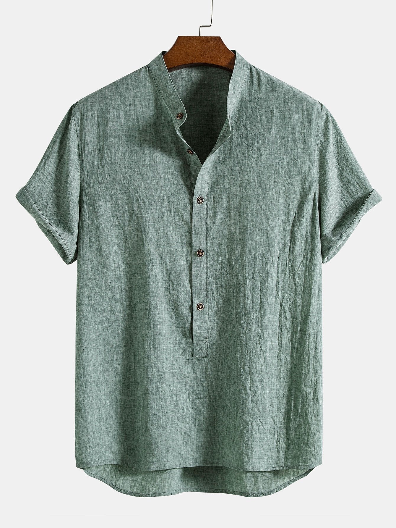 Green short-sleeve shirt on a hanger against a white background